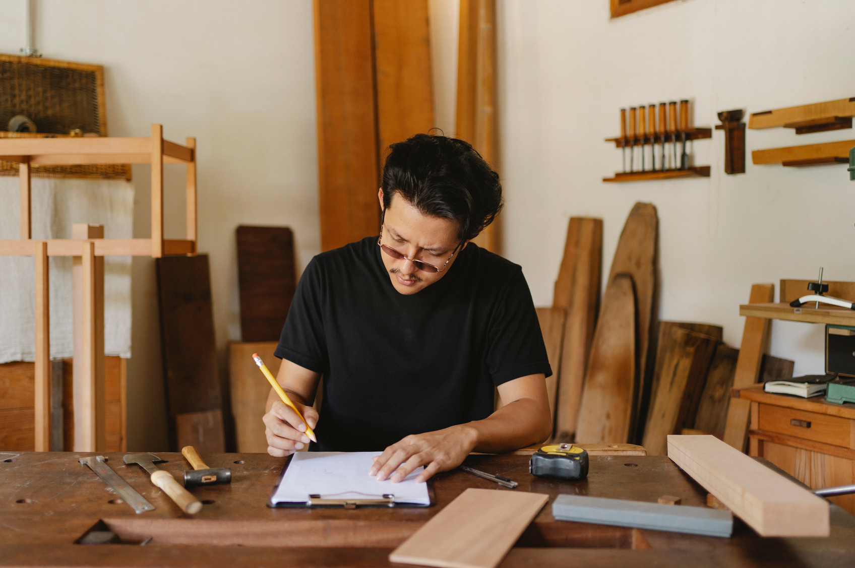 Focused ethnic craftsman working in creative carpenter studio